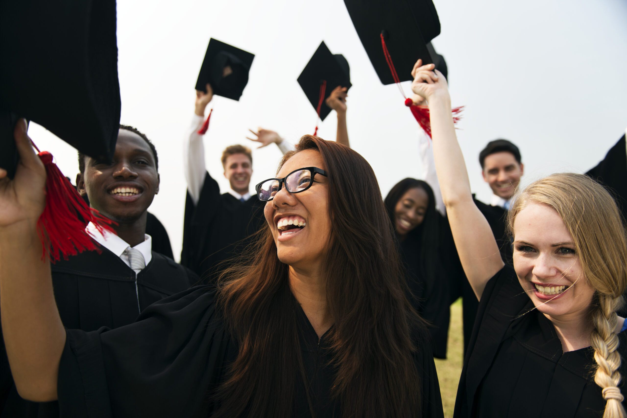 College graduates in caps and gowns celebrate after the commencement ceremony.